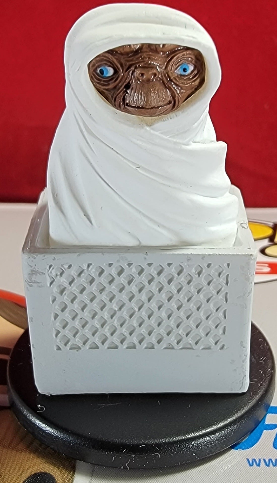 E.t. blind mini (2012)
brand new 1 3/4 inch e.t. wrapped in white sheet riding in a bicycle basket. item is produced by wizkids/neca llc.